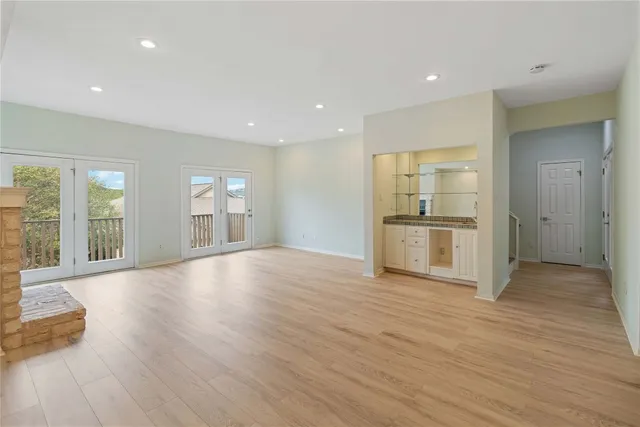 a view of empty room with wooden floor and windows