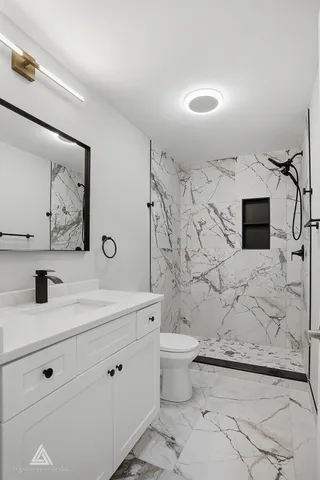 a bathroom with a sink toilet a mirror and shower