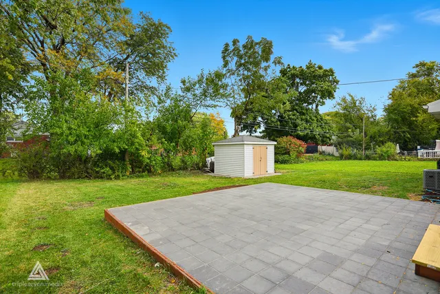 a view of a house with a big yard and large trees