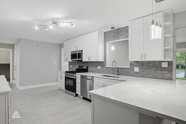 a kitchen with a sink a stove and cabinets