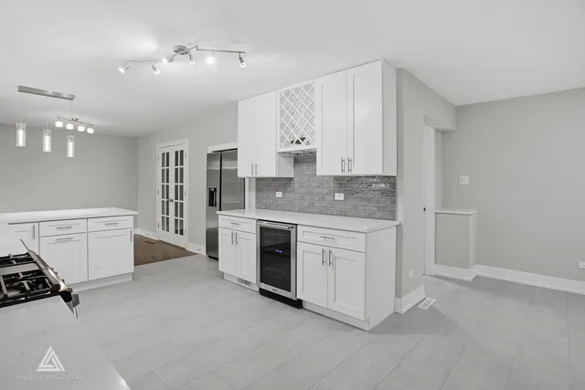 a kitchen with stainless steel appliances granite countertop a stove and white cabinets