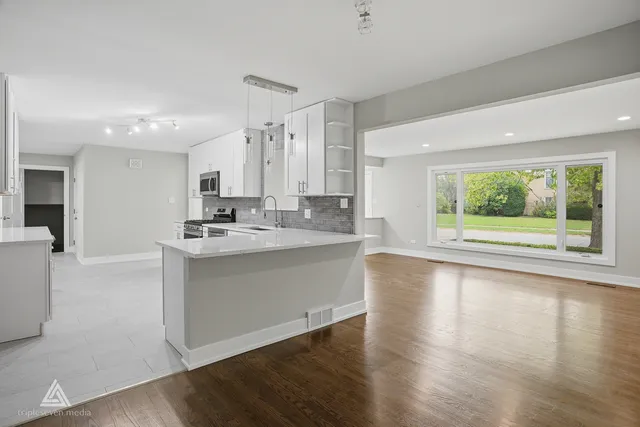 a large white kitchen with a large window