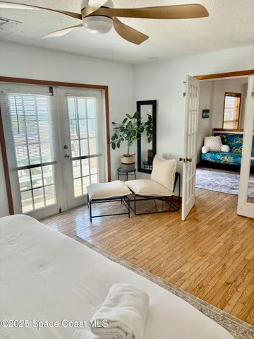 a dining room with wooden floor a chandelier fan wooden floor and a chandelier