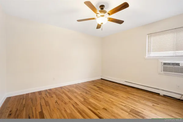 an empty room with a window and a ceiling fan