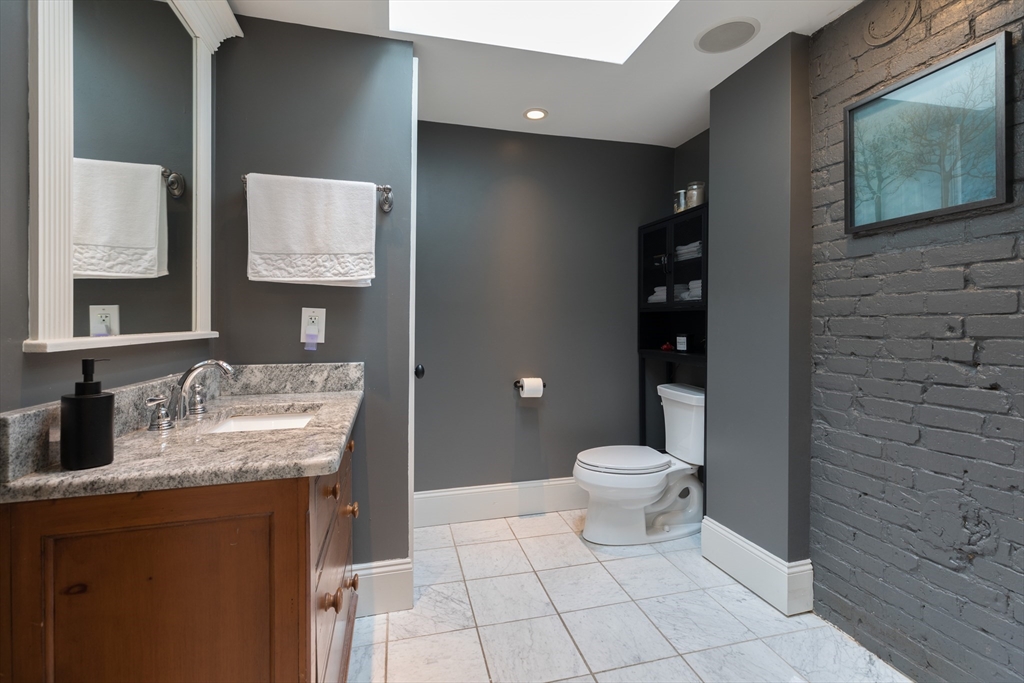 571 East 3rd Street Boston, MA 02127 - Photo 14 of 20 a bathroom with a granite countertop sink a toilet and a mirror