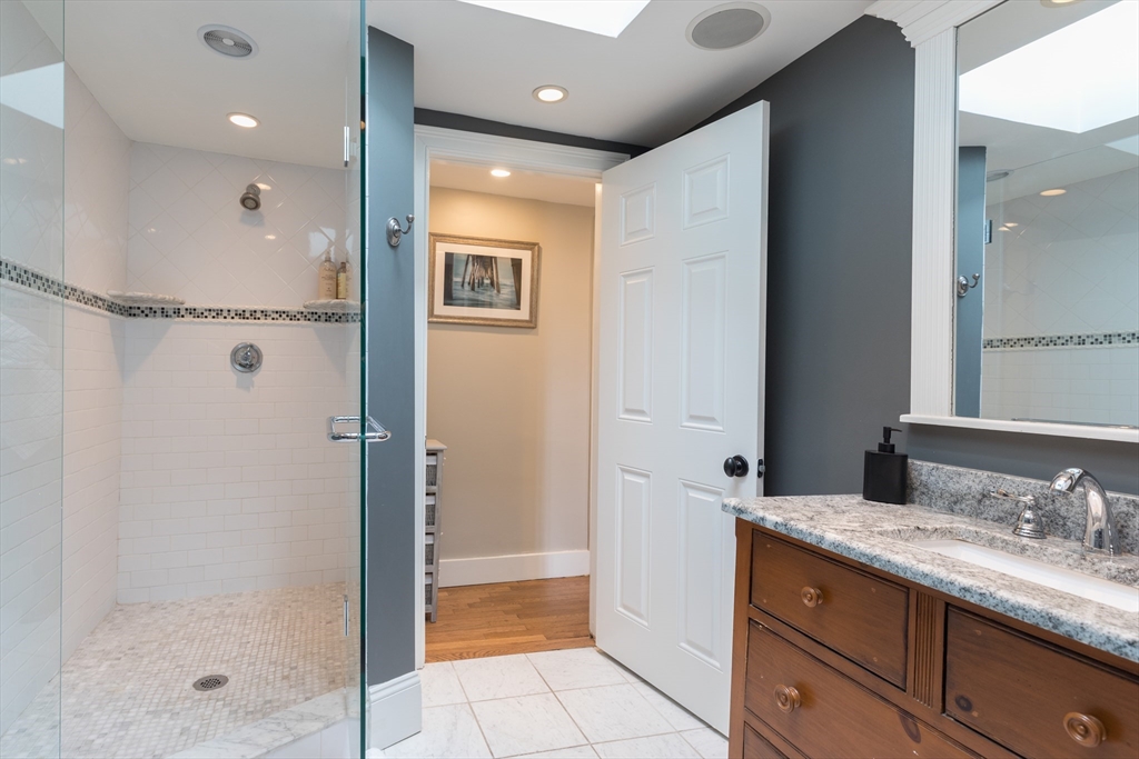571 East 3rd Street Boston, MA 02127 - Photo 15 of 20 a bathroom with a granite countertop sink a mirror and a shower