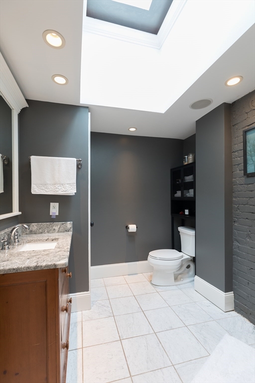 571 East 3rd Street Boston, MA 02127 - Photo 16 of 20 a bathroom with a sink a toilet and a mirror