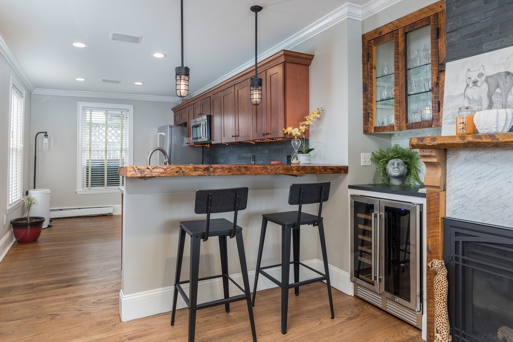 571 East 3rd Street Boston, MA 02127 - Photo 2 of 20 a kitchen with stainless steel appliances granite countertop a stove top oven a refrigerator a sink and a dining table with wooden floor