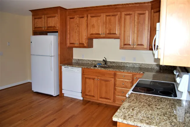 a kitchen with stainless steel appliances granite countertop a refrigerator sink and cabinets