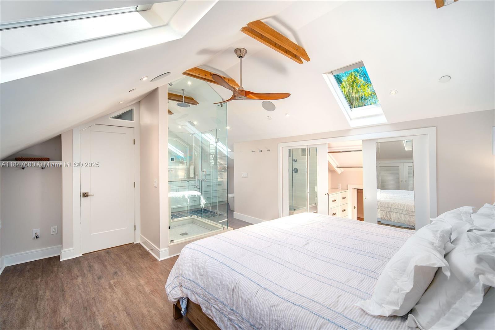 1114 Packer Street Key West, FL 33040 - Photo 89 of 98 a bedroom with a bed and a large mirror with wooden floor