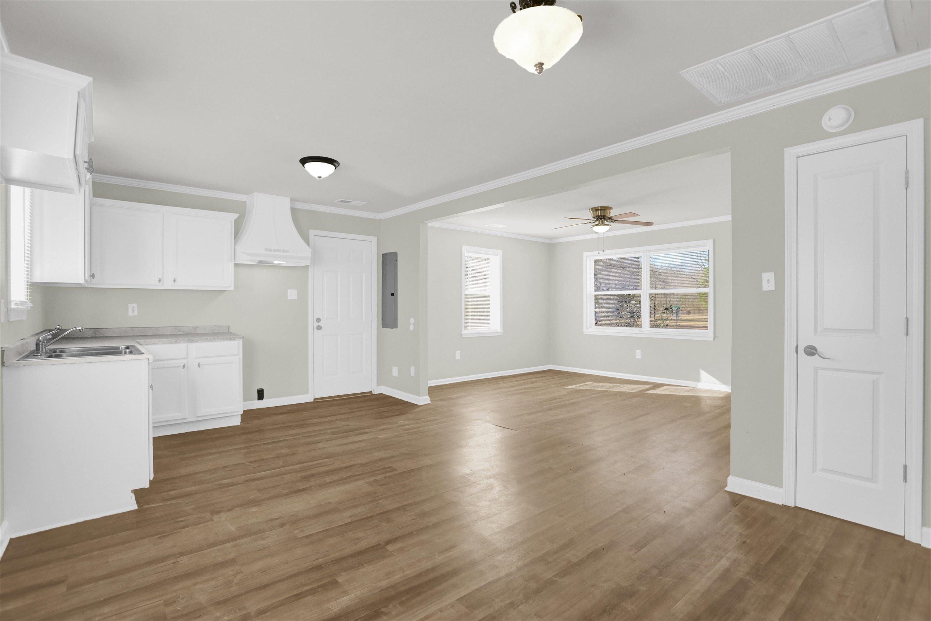 a view of empty room with wooden floor and windows