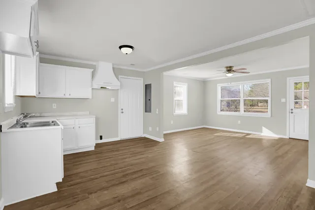 a view of a kitchen with wooden floor and a window