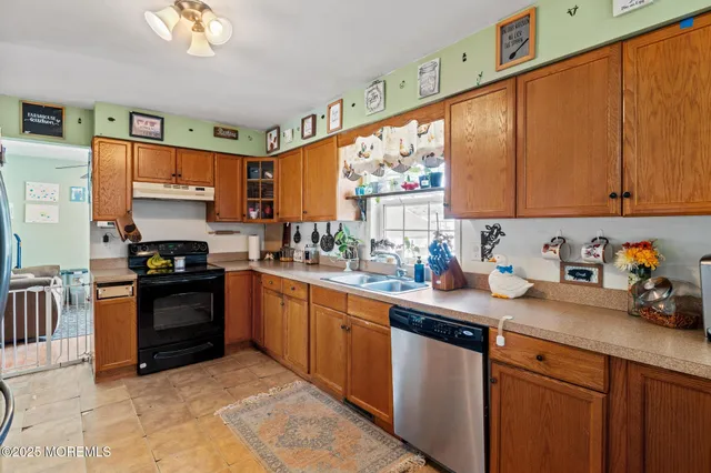 a kitchen with granite countertop a stove top oven sink and cabinets