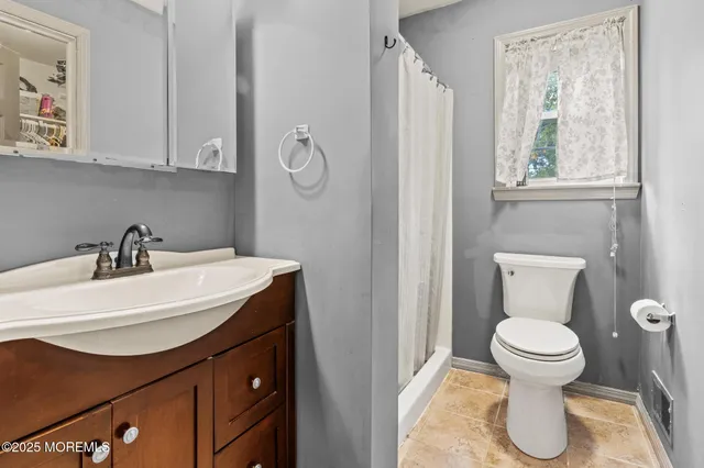 a bathroom with a sink toilet and a window