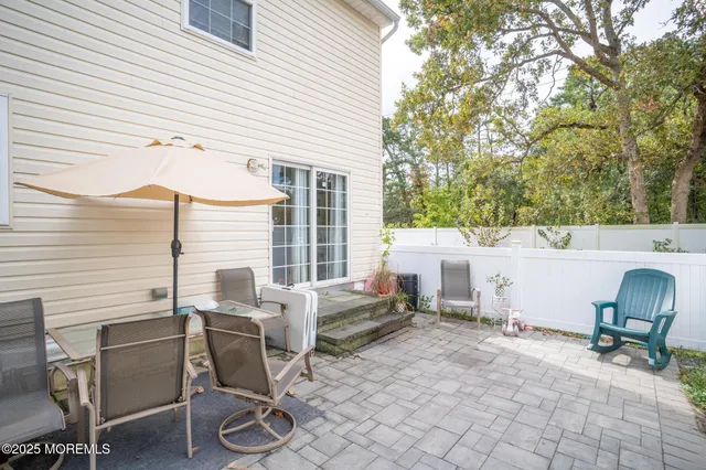 a view of a patio with a table and chairs and a barbeque