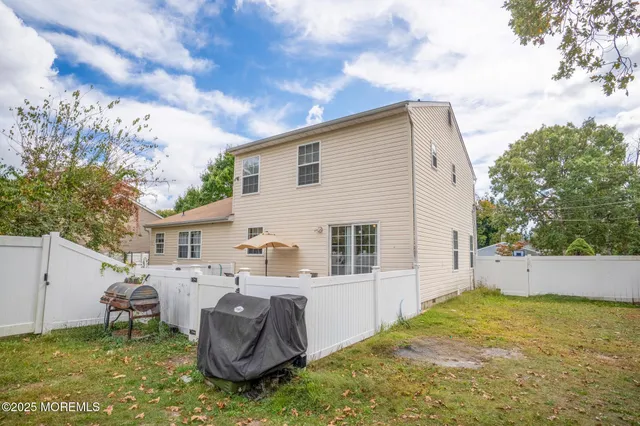 a view of a house with backyard and sitting area