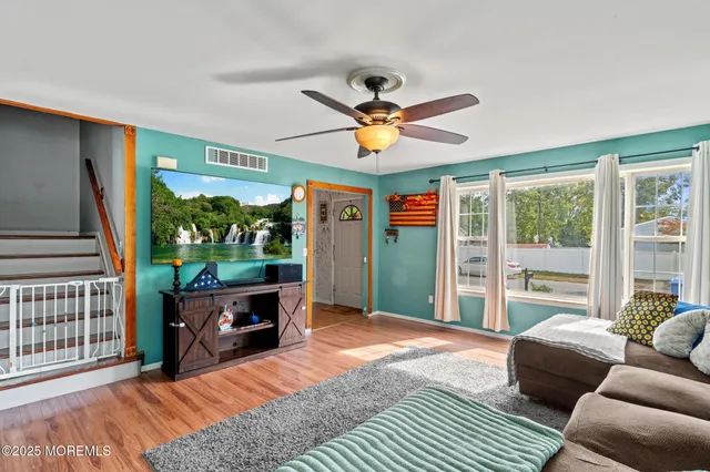 a living room with furniture a window and a flat screen tv