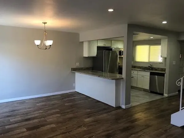 a kitchen with stainless steel appliances granite countertop a refrigerator and a sink