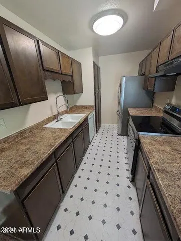 a kitchen with sink stove and refrigerator