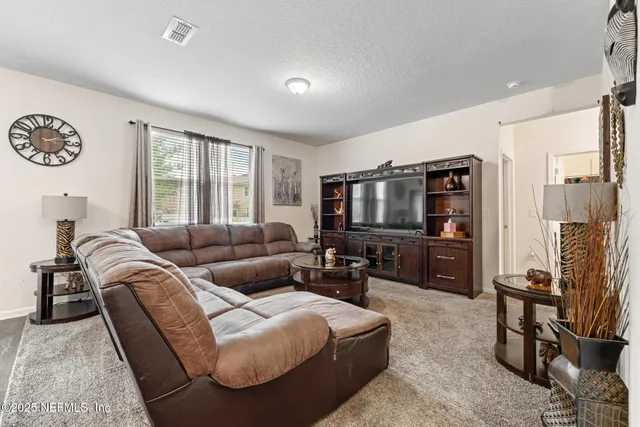 a kitchen with stainless steel appliances granite countertop a stove top oven a sink a dining table and chairs