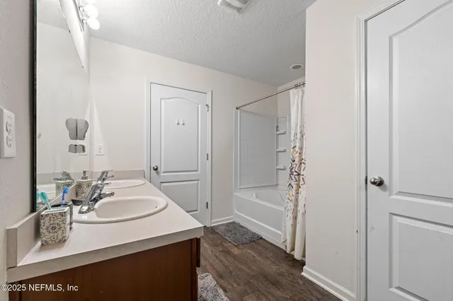 a bedroom with a bed and a flat tv screen on the dresser