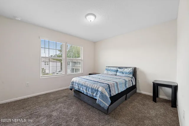 a bedroom with a bed and a table chair