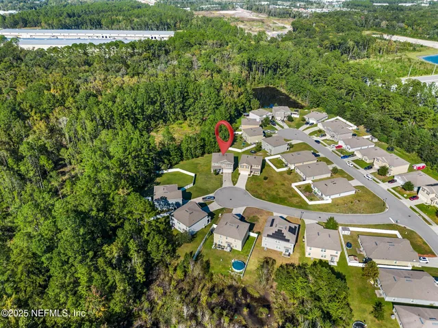 a view of a house with a big yard potted plants and large tree