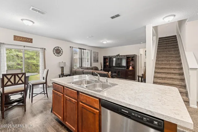 a kitchen with granite countertop a sink and chairs