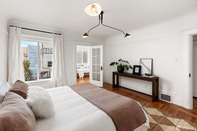 a bedroom with a bed window and wall painting