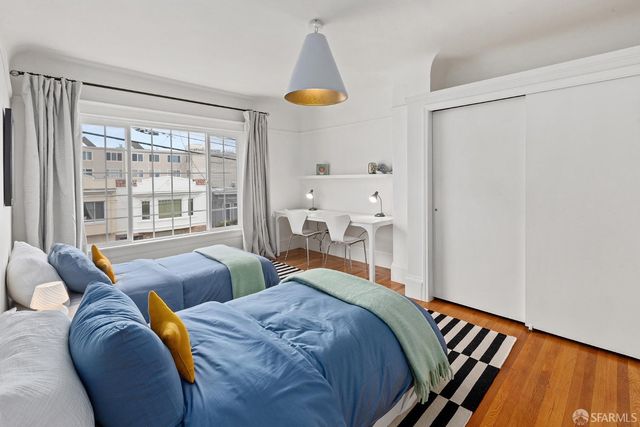 a bedroom with 2 bed and a window