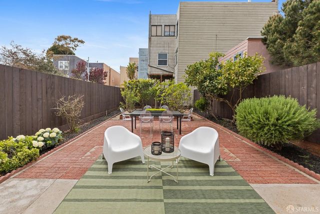 a view of a chairs and table in a backyard