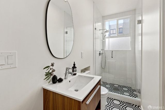 a bathroom with a sink a mirror and a shower