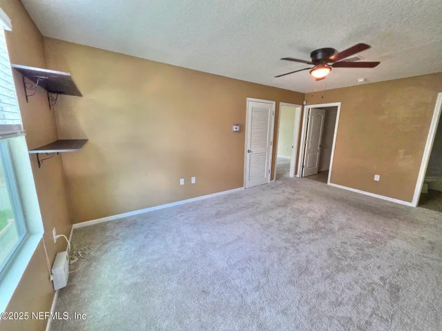 a view of a livingroom with a ceiling fan and wooden floor