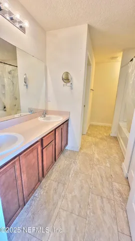 a spacious bathroom with a granite countertop sink and a mirror