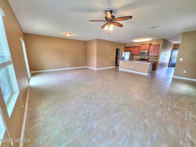 a view of a livingroom with furniture a ceiling fan and window