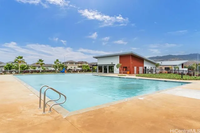 a front view of a house with swimming pool having outdoor seating
