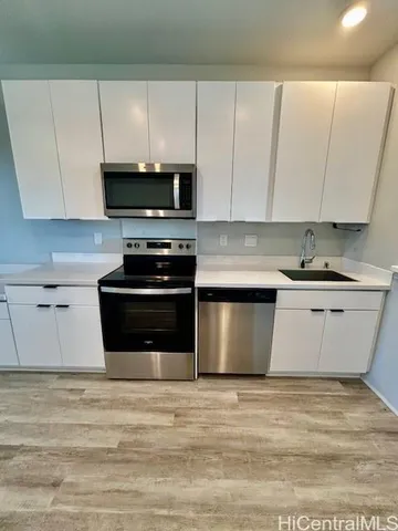 a kitchen with stainless steel appliances granite countertop a stove a sink and a microwave