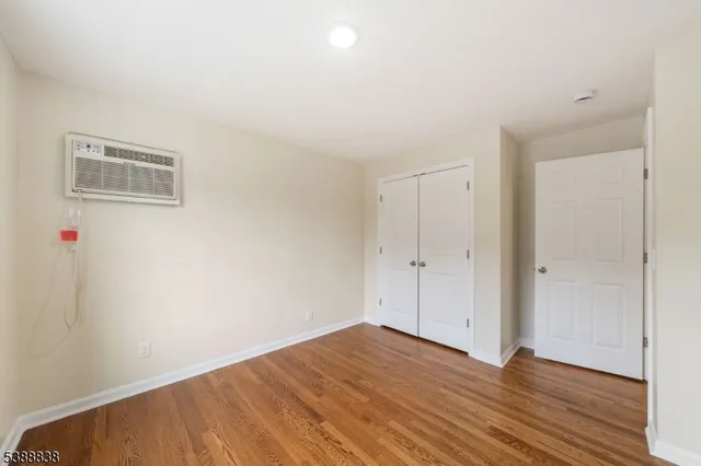 a view of a room with wooden floor and white walls