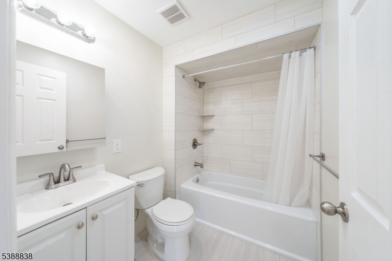 2429 Vauxhall Road Union, NJ 07083 - Photo 17 of 24 a bathroom with a bathtub shower sink vanity mirror and toilet