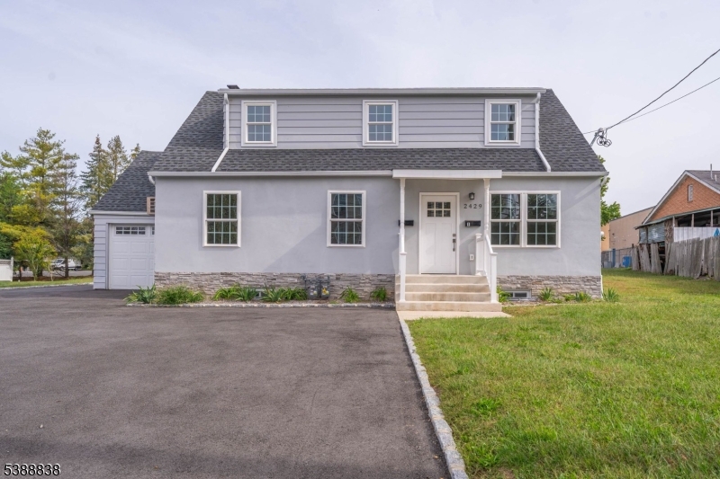 2429 Vauxhall Road Union, NJ 07083 - Photo 2 of 24 a front view of a house with a yard and garage