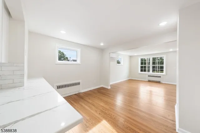 a view of a bedroom with wooden floor and windows