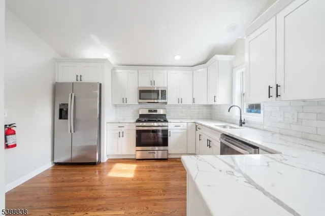 a kitchen with granite countertop a refrigerator stove and sink