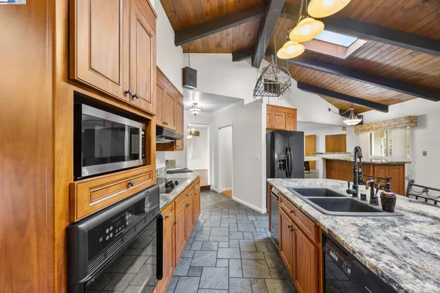 a kitchen with stainless steel appliances granite countertop a stove a sink dishwasher and cabinets