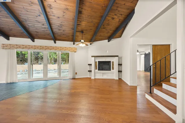 a view of a livingroom with a chandelier fan and a kitchen