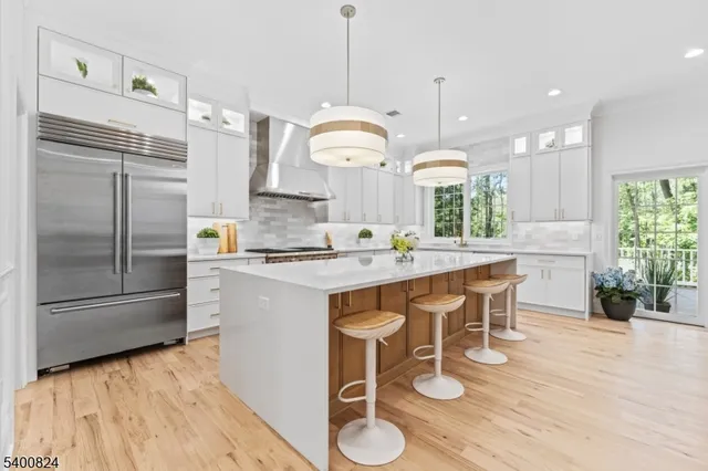 a kitchen with stainless steel appliances granite countertop a refrigerator a sink and a stove