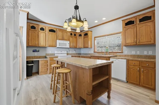 a kitchen with stainless steel appliances granite countertop a stove a sink dishwasher and a refrigerator with wooden floor