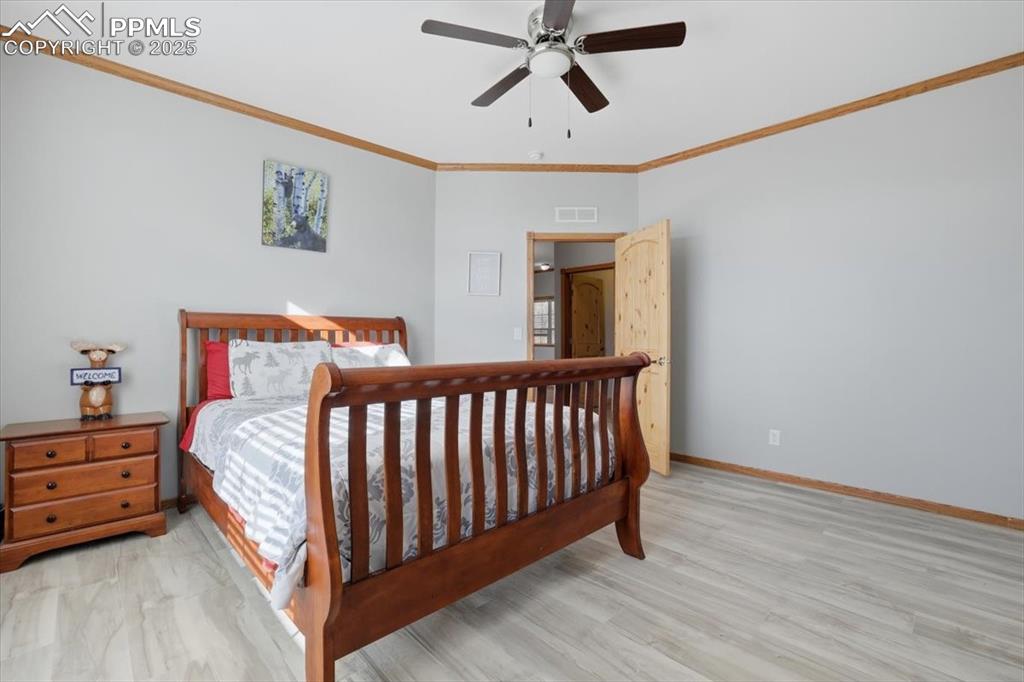 204 Crooked Creek Road Fairplay, CO 80440 - Photo 21 of 50 a spacious bedroom with a bed and a chandelier