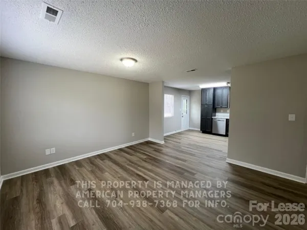 a view of an empty room and window and wooden floor