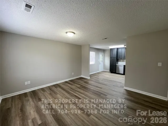 a view of an empty room and window and wooden floor