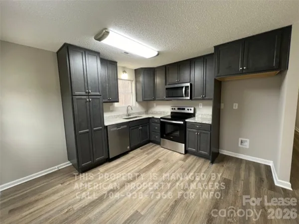 a kitchen with granite countertop stainless steel appliances and wooden cabinets